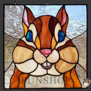 May include: Stained glass panel depicting a cartoon squirrel in shades of brown, tan, and orange. The squirrel has blue eyes and a pink nose. The panel is framed in black and includes the text "FUNSHOP" at the bottom.