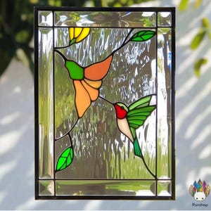 May include: Stained glass window panel featuring two hummingbirds in flight. One hummingbird is green and red, the other is green, orange, and yellow. The hummingbirds are flying near a flower with green leaves.