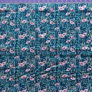 May include: A teal blue fabric with a repeating pattern of pink flamingos and green foliage.