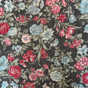 May include: A dark gray fabric with a floral pattern featuring pink, red, and blue flowers. The fabric has a subtle texture and a repeating pattern.