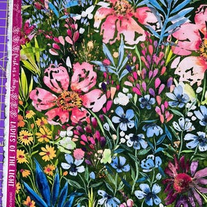 May include: A green fabric with a floral pattern. The flowers are pink, blue, yellow, and purple. The fabric has a watercolor effect.