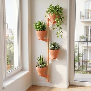 Op de afbeelding: Een verticale plantenstandaard met een centrale paal van licht hout en vier bevestigde, perzikkleurige, geribbelde plastic potten. Elke pot bevat een andere groene plant, waaronder een hangplant, kruiden en verschillende vetplanten.