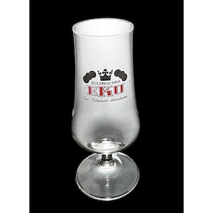 Puede incluir: Una copa de cerveza transparente con base y cuenco acampanado. La copa presenta el logotipo "KULMBACHER EKU" en rojo y negro, con un diseño de corona y lúpulo. La copa está diseñada para cerveza.