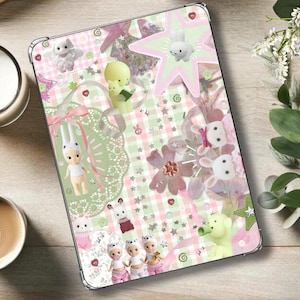 May include: A tablet case with a whimsical design featuring bunnies, stars, and flowers in pastel pink, green, and white. The case has a gingham pattern background and decorative elements.