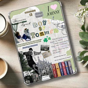 May include: A clear phone case with a collage design featuring text, images, and a rugby player. The text includes "BOYS OF TOMMEN", "I LOVE JOHNNY", and "Shannon Lynch". The case is on a wooden surface with a candle and a cup of coffee.