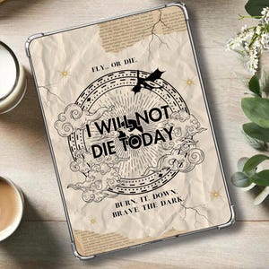 May include: A white and beige iPad case with a black and white illustration of a dragon and clouds. The text "FLY... OR DIE. I WILL NOT DIE TODAY BURN. IT. DOWN. BRAVE THE DARK." is printed on the case.