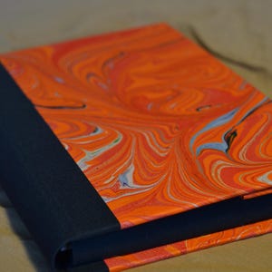 Könnte beinhalten: Ein Set aus drei Keramikbechern mit gesprenkelter, matter Oberfläche. Die Becher sind in Creme-, Hellgrau- und Dunkelgrautönen gehalten. Jeder Becher hat ein schlichtes, minimalistisches Design.