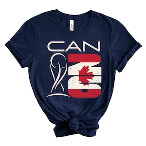 May include: Navy blue t-shirt with a graphic design that says "CAN" in white letters, with the "A" replaced by a stylized figure. The "N" and "O" are in the colors of the Canadian flag.