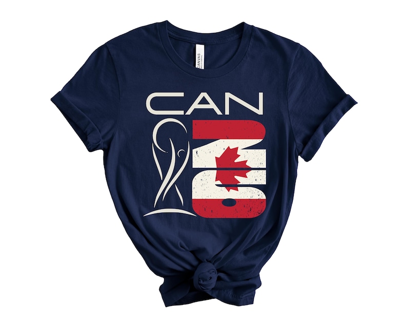 May include: Navy blue t-shirt with a graphic design that says "CAN" in white letters, with the "A" replaced by a stylized figure. The "N" and "O" are in the colors of the Canadian flag.