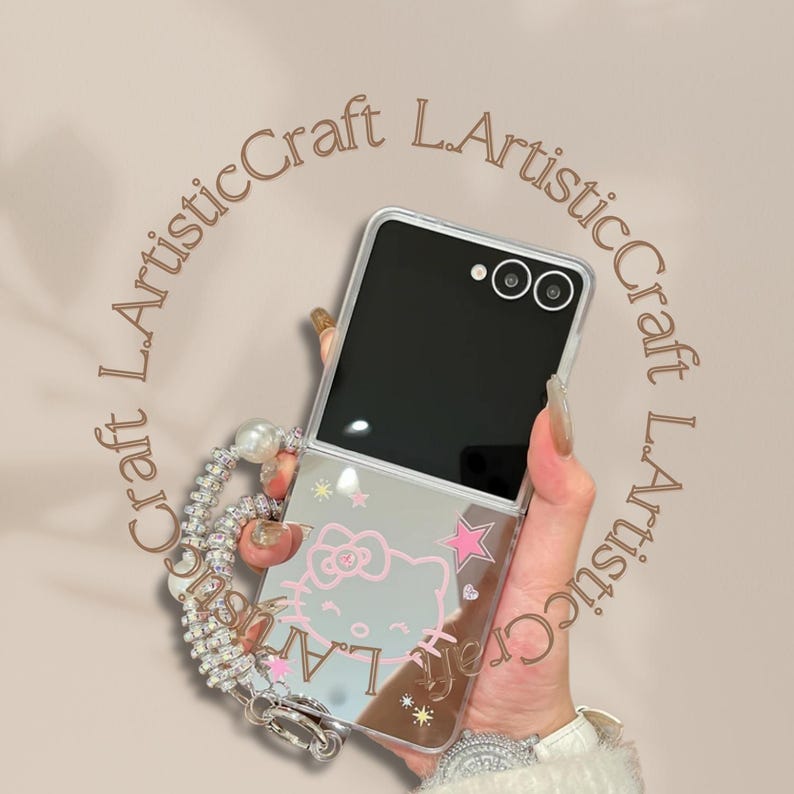 Pu&ograve; includere: Custodia per telefono trasparente con finitura a specchio, con un design di Hello Kitty rosa e dettagli a stella. La custodia &egrave; tenuta da una catena decorativa con perle e strass. Lo schermo del telefono &egrave; nero.