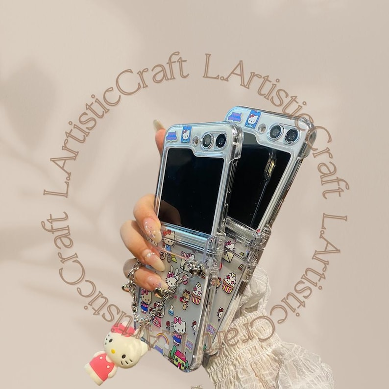 May include: Two clear phone cases with a Hello Kitty design. The cases are attached to each other with a chain. The cases are decorated with Hello Kitty characters and other cute designs.