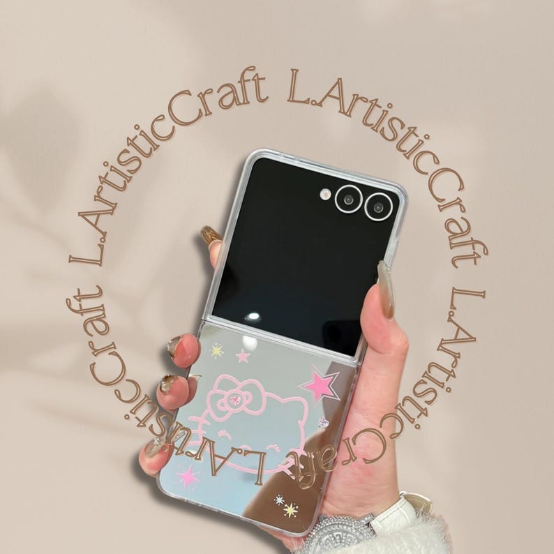 Pu&ograve; includere: Custodia trasparente per telefono con superficie a specchio con un design di Hello Kitty con stelle rosa e testo. La custodia &egrave; aperta, rivelando lo schermo e la fotocamera del telefono.
