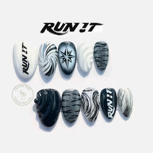 May include: A set of ten press-on nails featuring a monochromatic black, white, and grey colour palette. Designs include the text RUN IT, swirling patterns, a starburst, tiger stripes, and marble effects. The nails have a pointed almond shape.