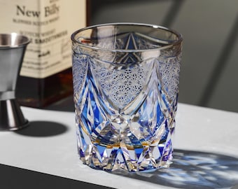 May include: A blue and clear glass tumbler with an intricate geometric pattern. The glass has a gold rim and is perfect for serving drinks.