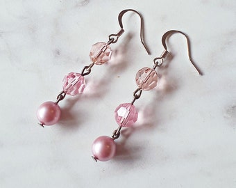 May include: A pair of pink crystal and pearl dangle earrings with silver hooks.