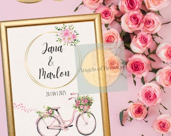 May include: A gold-framed wedding announcement with a pink bicycle decorated with flowers. The announcement reads "Jana & Marlon 20.04.1.2025" and "Der schönste Weg, ist der gemeinsame".