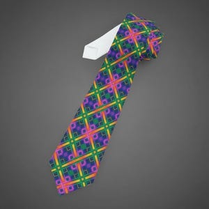 May include: A patterned necktie with a vibrant design. The tie features a repeating geometric pattern in green, purple, orange, and yellow. The tie's interior is white. The tie is angled against a grey background.