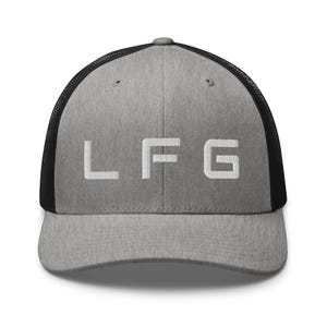 May include: A grey trucker cap with a black mesh back. The front of the cap features the white letters "LFG" in a bold, sans-serif font. The cap has a curved peak and a snapback fastening.