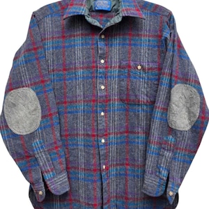 May include: A gray, blue, and red plaid flannel shirt with elbow patches. The shirt has a button-down front, a collar, and a chest pocket. The elbow patches are a lighter gray color.