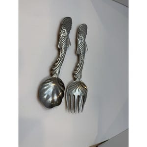 May include: A set of three ceramic mugs with a speckled, matte finish. The mugs are in shades of cream, light gray, and dark gray. Each mug has a simple, minimalist design, perfect for coffee or tea.