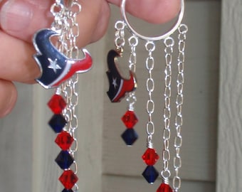 May include: Silver hoop earrings with red and blue crystal beads and a charm of a football team logo.