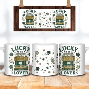 May include: White ceramic mugs with a "Lucky to be a Book Lover" design. The design includes stacks of books, shamrocks, and floral elements in green, gold, and white. A wooden sign with the same design hangs above the mugs.