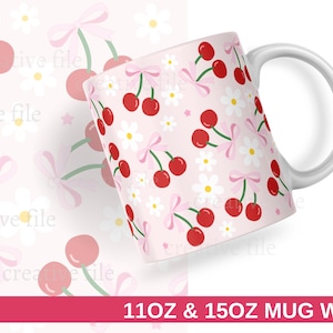 May include: A white ceramic mug with a pink cherry and daisy pattern. The design features red cherries, white daisies, and pink bows on a light pink background. The mug has a white handle and the text "11OZ & 15OZ MUG WRAP" at the bottom.