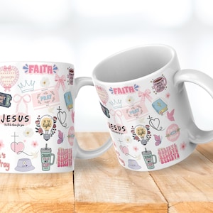 May include: Two white ceramic mugs with a variety of pink and light blue graphics. The mugs feature the words "Faith", "Jesus", and "Pray", along with other religious symbols and phrases. The mugs are on a wooden surface.