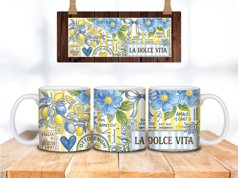 May include: Three white ceramic mugs with a design featuring lemons, blue flowers, and the text "LA DOLCE VITA." The design includes the words "ITALIA" and "AMALFI COAST." The mugs are on a wooden surface.