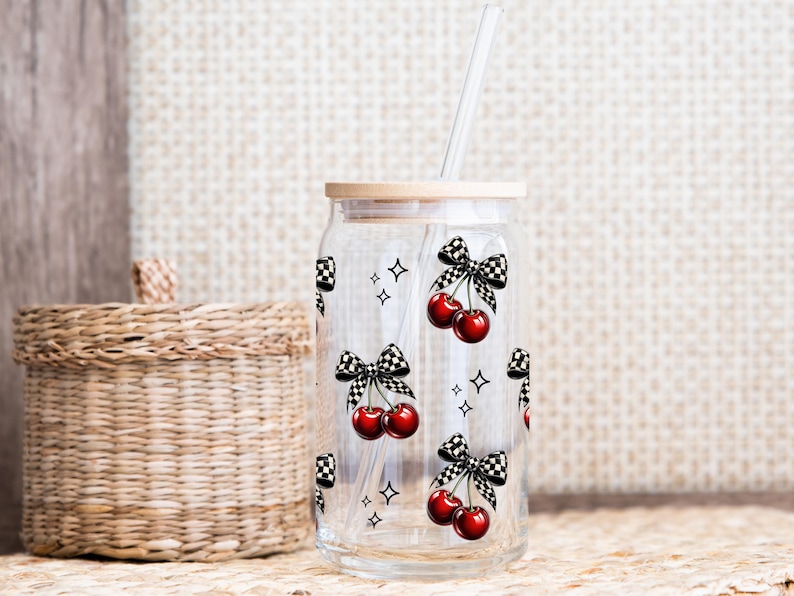 Peut inclure: Un gobelet en verre transparent en forme de canette avec un couvercle en bambou et une paille transparente. Le gobelet est d&eacute;cor&eacute; de cerises rouges, de n&oelig;uds &agrave; carreaux noirs et blancs et de petites &eacute;toiles. Le motif est r&eacute;p&eacute;t&eacute; sur le verre.