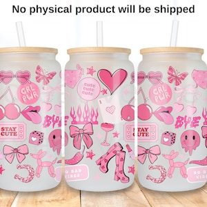 May include: Three glass can-shaped tumblers with bamboo lids and straws. Each tumbler is decorated with pink graphics including hearts, cherries, bows, and the words "GRL PWR" and "STAY CUTE". The tumblers are on a wooden surface.