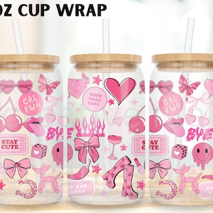 May include: Three clear glass cups with wooden lids and straws, each wrapped with a pink design. The design includes hearts, bows, cherries, and the text "GRL PWR" and "STAY CUTE". The cups are labeled "16 OZ CUP WRAP".