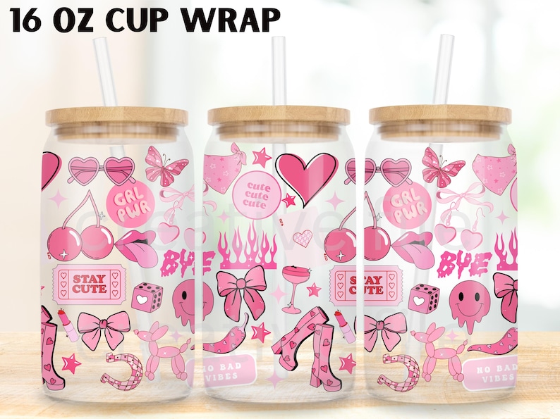 May include: Three clear glass cups with wooden lids and straws, each wrapped with a pink design. The design includes hearts, bows, cherries, and the text "GRL PWR" and "STAY CUTE". The cups are labeled "16 OZ CUP WRAP".