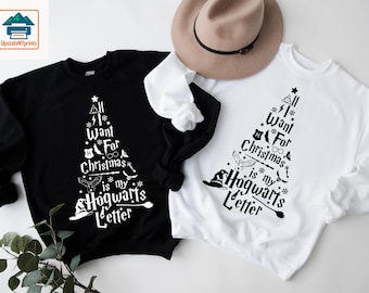 May include: Black and white sweatshirts with a Christmas tree design. The tree is made up of Harry Potter-themed icons and the text "All I Want For Christmas is my Hogwarts Letter". A tan hat is on top of the white sweatshirt.