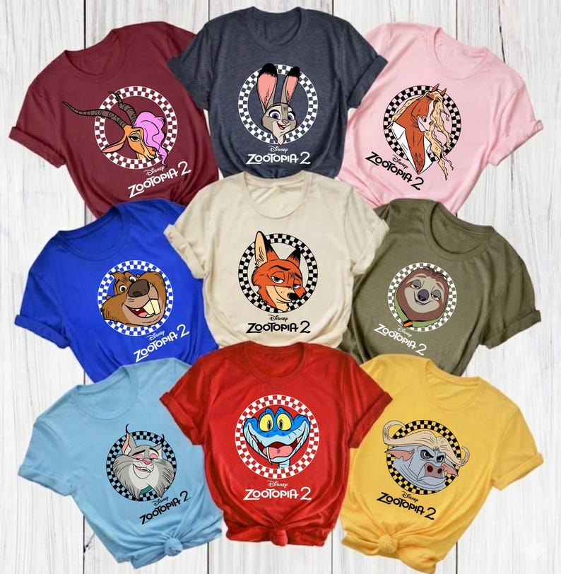 May include: A collection of colorful t-shirts featuring characters from the movie "Zootopia 2." Each shirt displays a different character within a checkered circle, with the movie title below. Colors include red, blue, pink, and yellow.