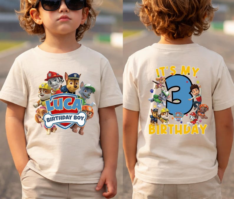 May include: A beige short-sleeve t-shirt featuring Paw Patrol characters. The front displays the name Luca and the text Birthday Boy. The back features a large blue number 3 with the text It's My Birthday and additional character graphics.