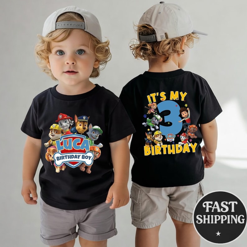 May include: A black t-shirt featuring Paw Patrol characters and the text LUCA BIRTHDAY BOY on the front, and the text IT'S MY 3 BIRTHDAY with Paw Patrol characters on the back. The shirt is worn with light gray shorts and a light gray baseball cap.