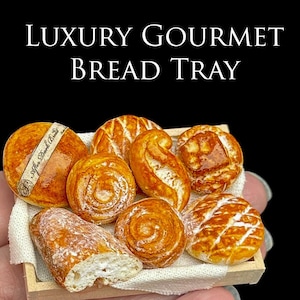 Puede incluir: Una bandeja de pan en miniatura con varios productos horneados, incluyendo panecillos y hogazas. El pan es de color marrón dorado con texturas detalladas, presentado en una pequeña bandeja de madera con un paño blanco. El texto "LUXURY GOURMET BREAD TRAY" se muestra arriba.