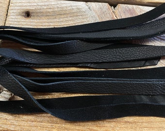 May include: A bundle of black leather strips, likely for crafting or leatherworking projects.