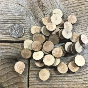 May include: A pile of wooden round discs with numbers 1-10 printed on them. The discs are approximately the size of a US quarter.