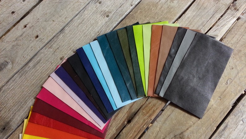 May include: A fan-shaped arrangement of leather swatches in various colors, including red, orange, yellow, green, blue, purple, pink, and brown. The swatches are arranged in a rainbow pattern.