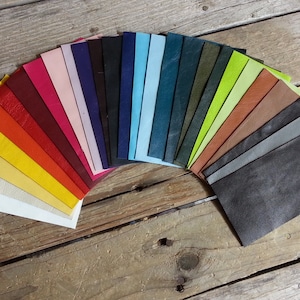 May include: A fan of leather swatches in various colors, including white, yellow, orange, red, burgundy, pink, black, blue, teal, green, brown, gray, and dark gray.
