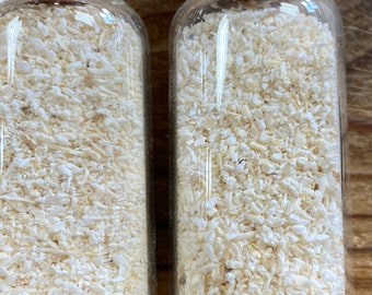 May include: Two clear glass jars filled with white, dried, shredded coconut flakes.