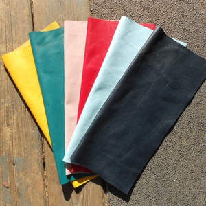 May include: A collection of six leather swatches in various colors, including yellow, teal, pink, red, light blue, and dark blue.
