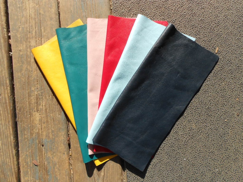 May include: A collection of six leather swatches in various colors, including yellow, teal, pink, red, light blue, and dark blue.