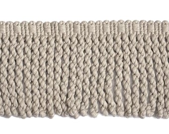 Può includere: Primo piano di un bordo con frange beige. Il bordo presenta un bordo superiore intrecciato con una serie di fili intrecciati verticali che creano una frangia. Il colore beige neutro è adatto a vari progetti di arredamento per la casa.