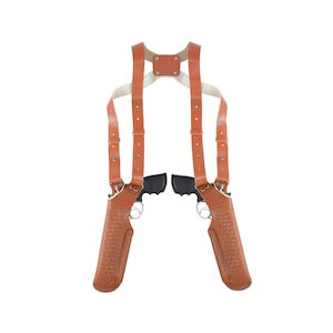 May include: A brown leather holster with two gun holsters attached to a brown leather harness. The harness has adjustable straps and is designed to be worn over the shoulders.