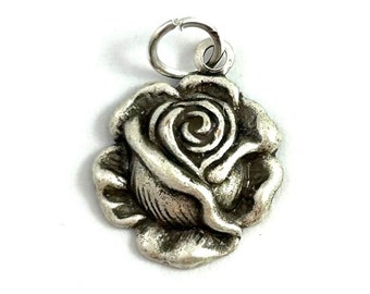 May include: A silver charm in the shape of a rose. The rose is detailed and has a textured surface.