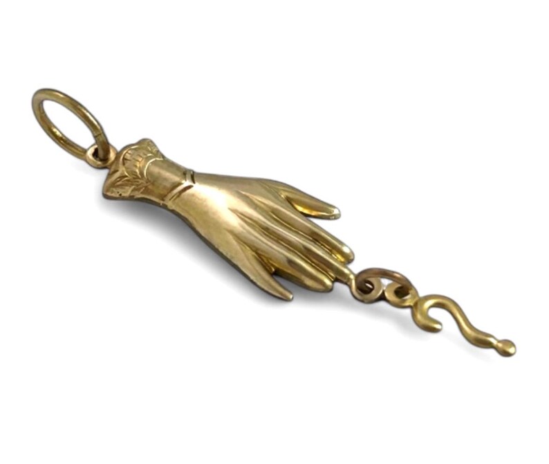 K&ouml;nnte beinhalten: Ein goldener Anh&auml;nger in Form einer Hand mit einem Fragezeichen am Finger.