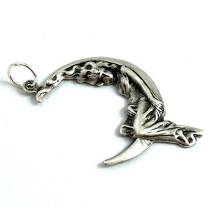 May include: A silver charm pendant featuring a woman reclining on a crescent moon. The charm has a loop for attaching to a necklace or bracelet.